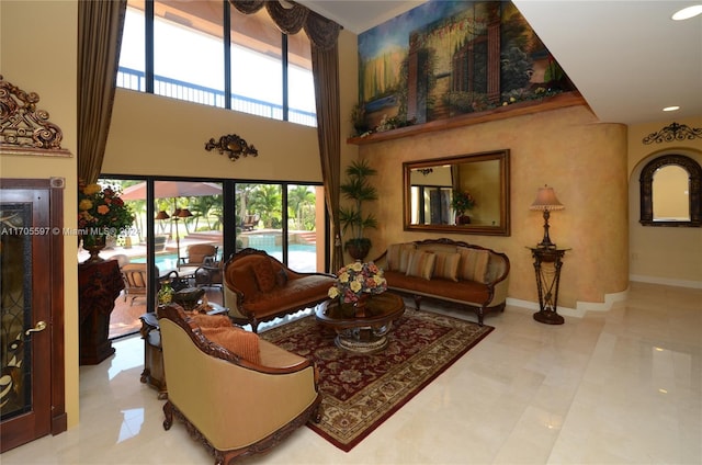 tiled living room with a towering ceiling and a healthy amount of sunlight