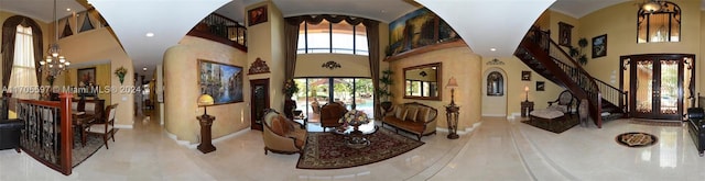 foyer featuring french doors, a high ceiling, and an inviting chandelier