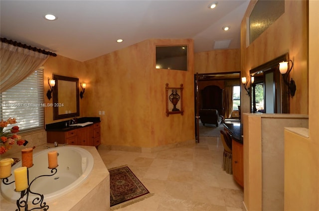 bathroom with tiled bath and vanity