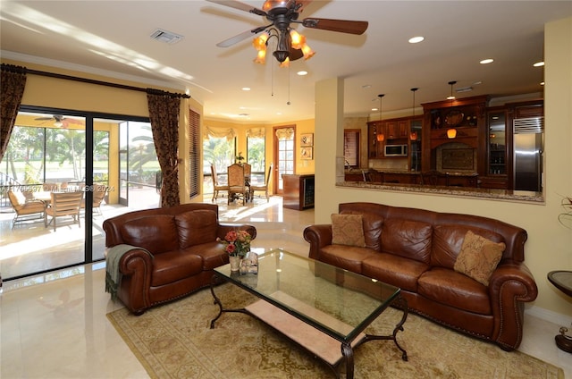 living room with ceiling fan and ornamental molding