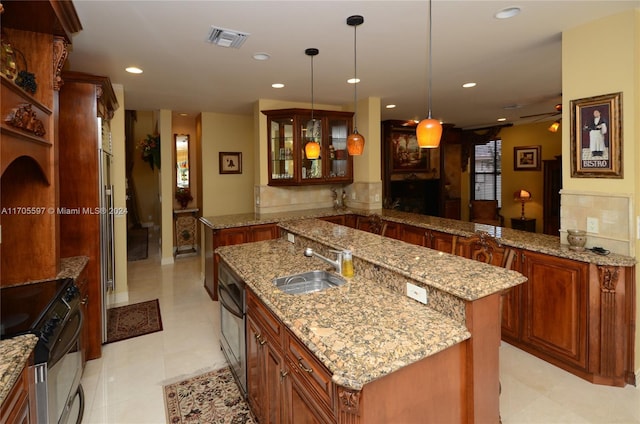 kitchen with sink, stainless steel range oven, kitchen peninsula, an island with sink, and pendant lighting