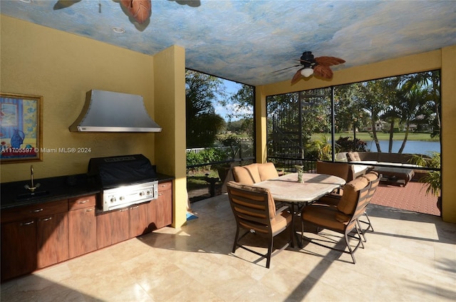 sunroom / solarium featuring ceiling fan and a water view