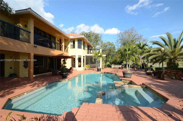 view of swimming pool with a patio area and an in ground hot tub