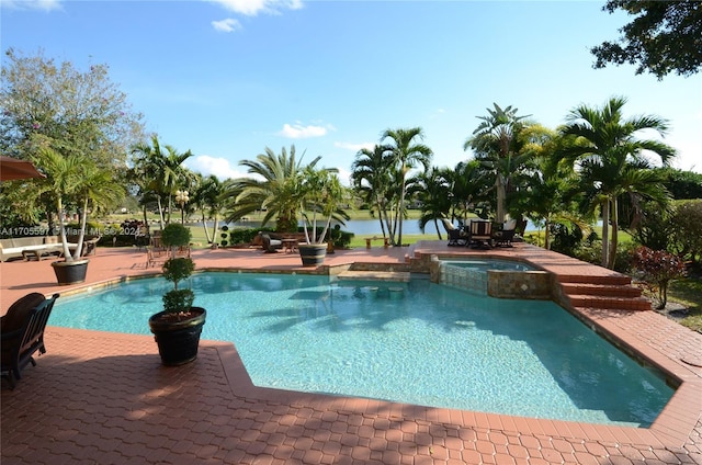 view of swimming pool featuring a water view, an in ground hot tub, and a patio