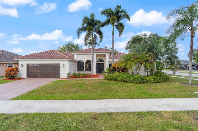 mediterranean / spanish-style house featuring a front yard and a garage