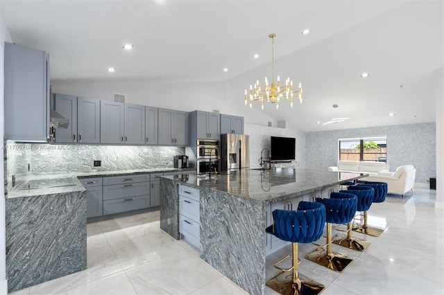 kitchen featuring dark stone countertops, a large island, lofted ceiling, and stainless steel refrigerator with ice dispenser