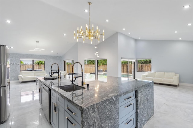 kitchen with pendant lighting, dark stone counters, a spacious island, sink, and plenty of natural light