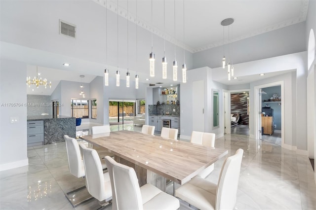 dining space featuring a towering ceiling and an inviting chandelier