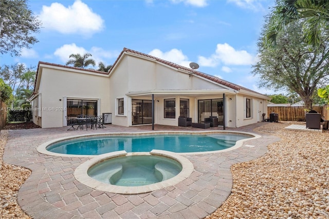 exterior space with a patio area, an outdoor hangout area, and a pool with hot tub