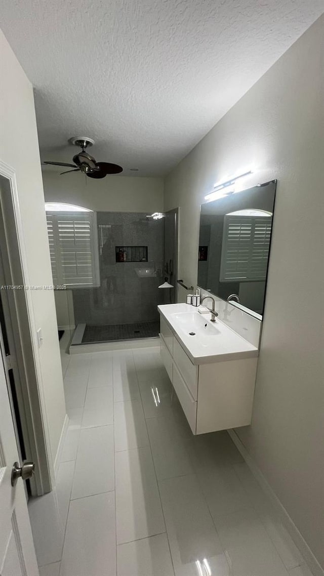 bathroom with vanity, a tile shower, tile patterned floors, and ceiling fan