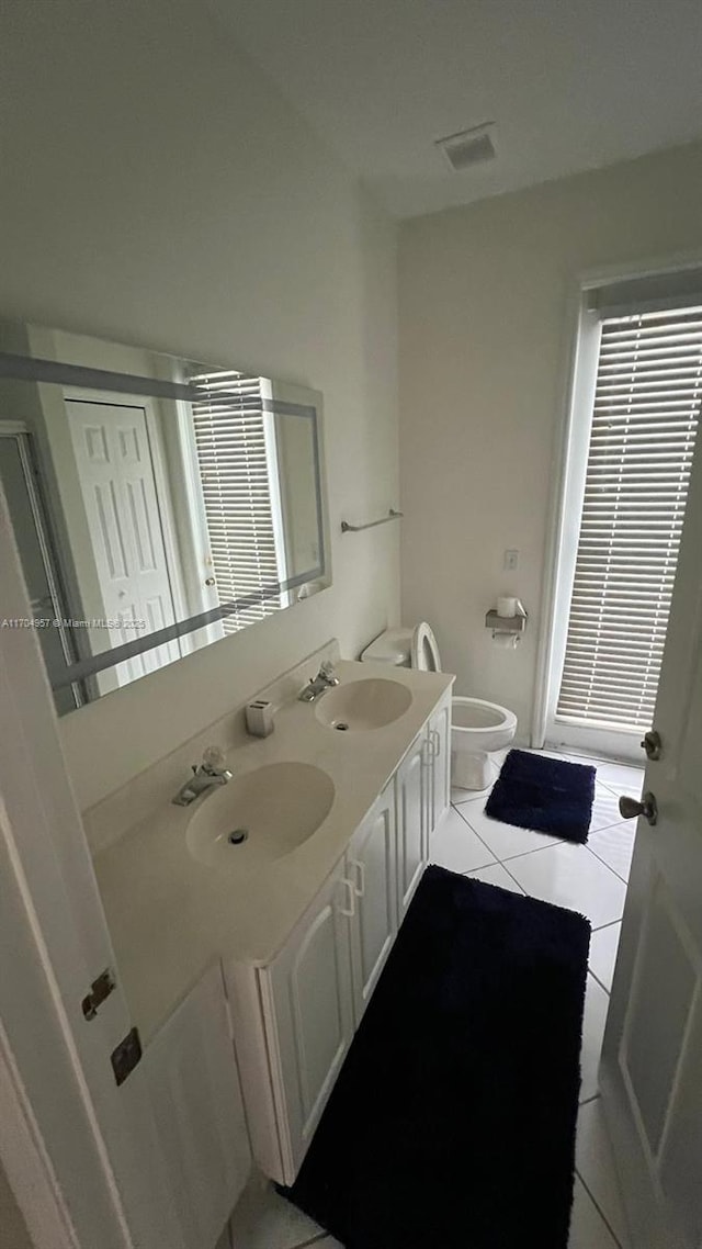 bathroom with tile patterned flooring, vanity, and toilet