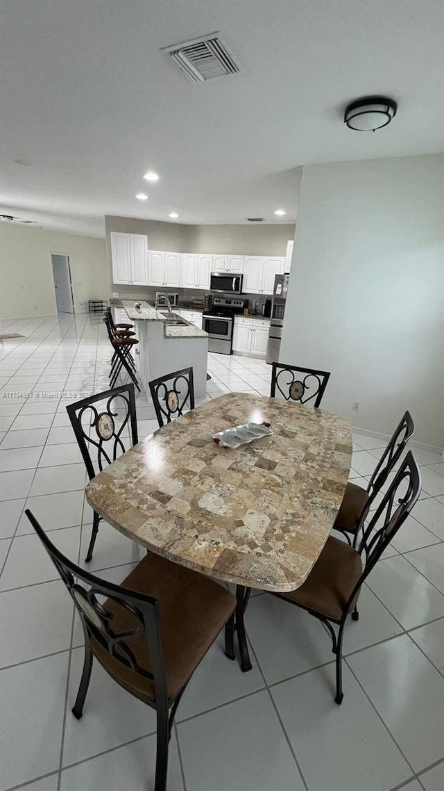 dining space with sink and light tile patterned floors