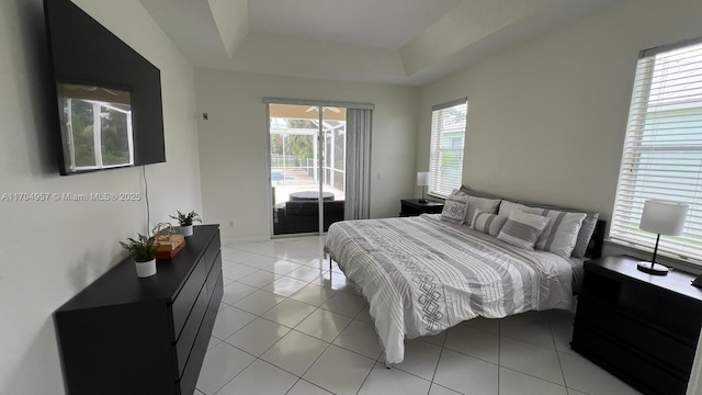 tiled bedroom featuring a raised ceiling and access to outside