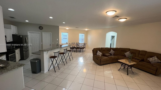 living room featuring light tile patterned flooring and a textured ceiling