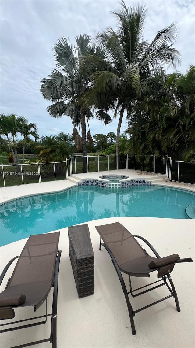 view of pool featuring an in ground hot tub