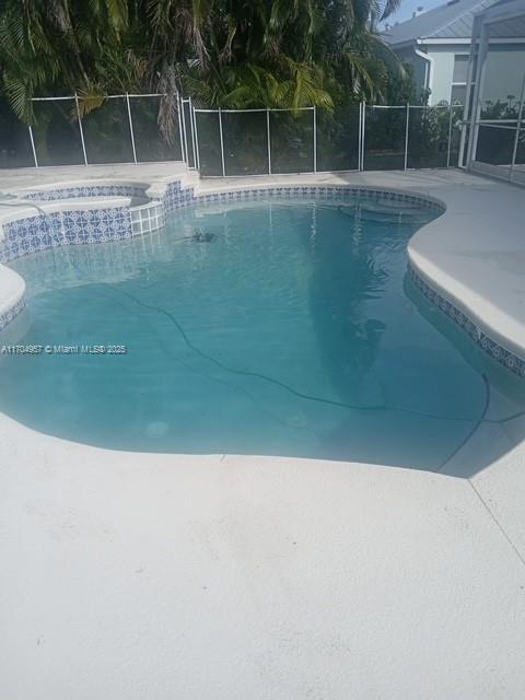 view of pool featuring glass enclosure