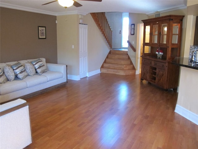 living room featuring ceiling fan, wood-type flooring, and crown molding