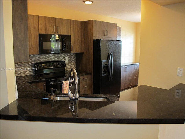 kitchen featuring sink, backsplash, kitchen peninsula, dark stone counters, and black appliances