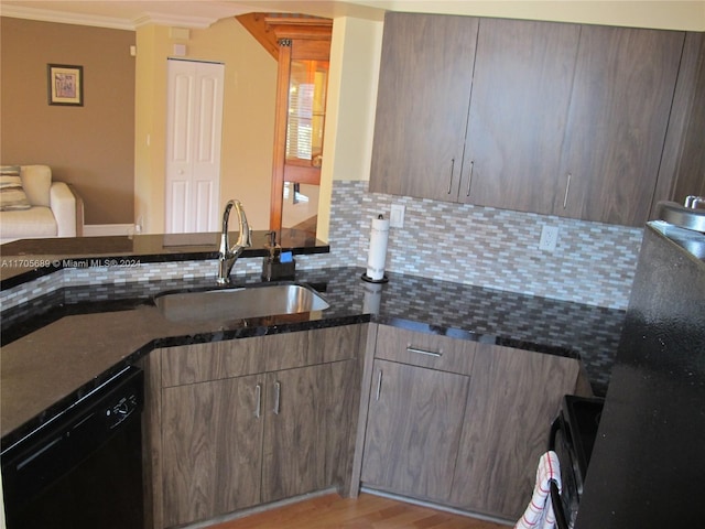 kitchen featuring dishwasher, sink, light hardwood / wood-style flooring, dark stone countertops, and ornamental molding