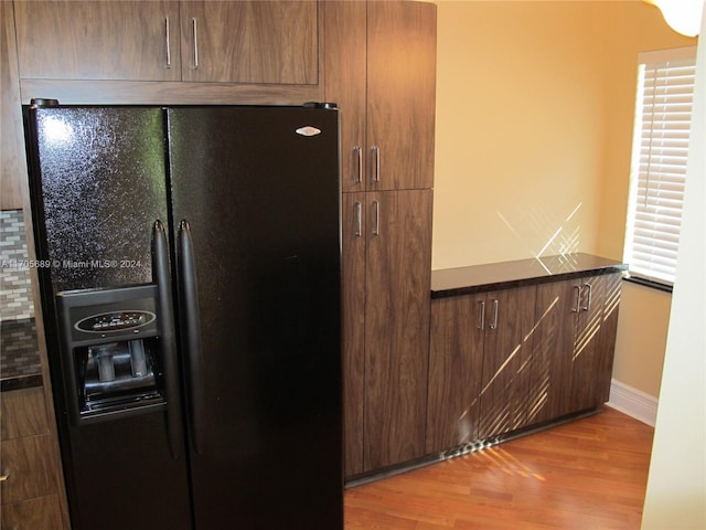 kitchen featuring black fridge and light hardwood / wood-style flooring