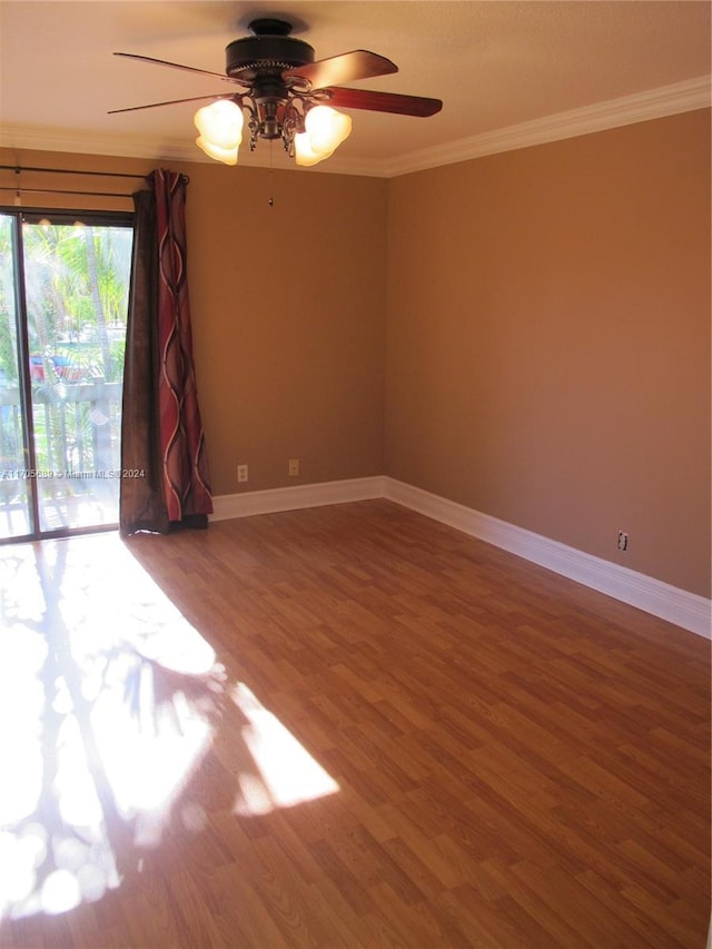 empty room featuring ceiling fan, wood-type flooring, and ornamental molding