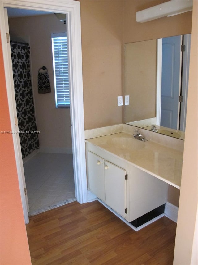 bathroom with hardwood / wood-style flooring, vanity, and walk in shower