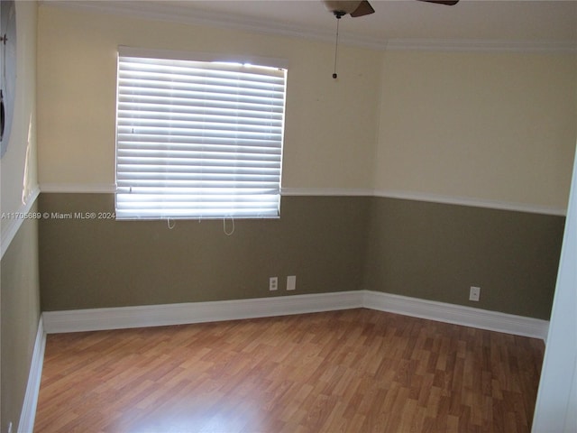 empty room featuring ceiling fan, wood-type flooring, and crown molding