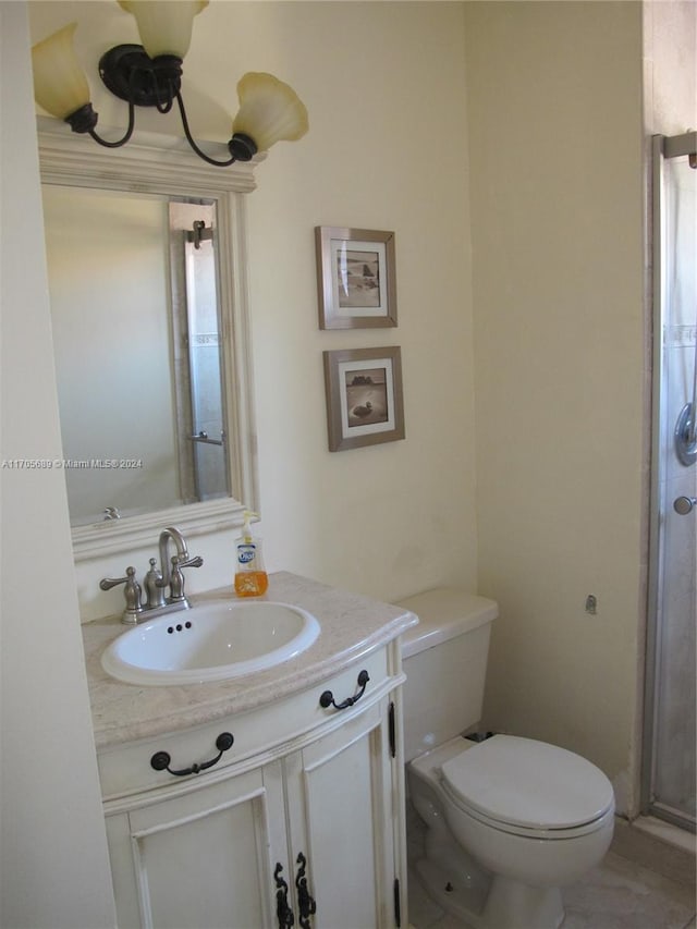 bathroom featuring vanity, an enclosed shower, and toilet