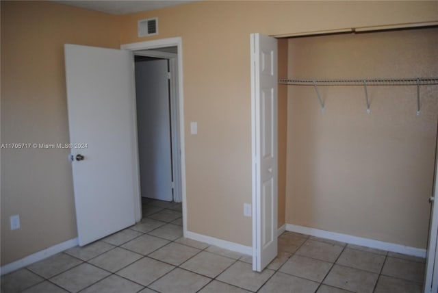 unfurnished bedroom with a closet and light tile patterned floors