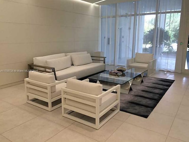 tiled living room featuring floor to ceiling windows