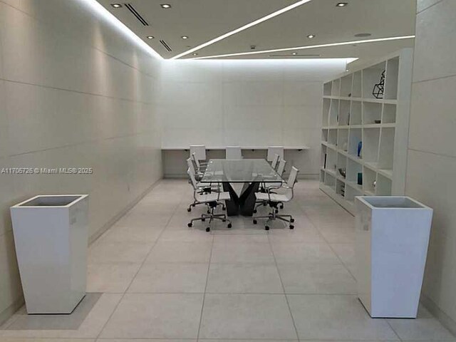 tiled dining space featuring built in shelves