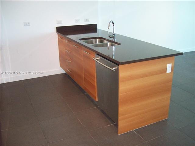 kitchen featuring dishwasher, sink, and dark tile patterned floors