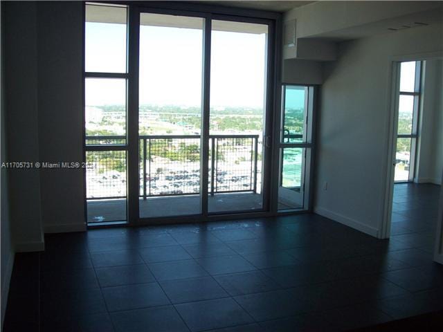 unfurnished room with dark tile patterned flooring