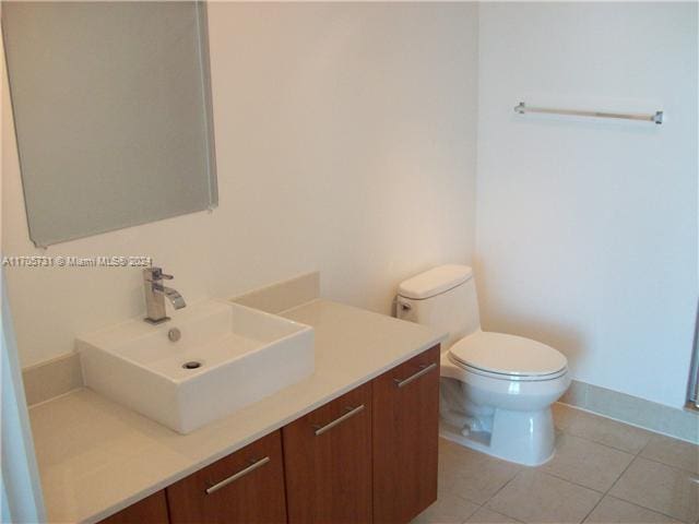 bathroom featuring tile patterned floors, vanity, and toilet