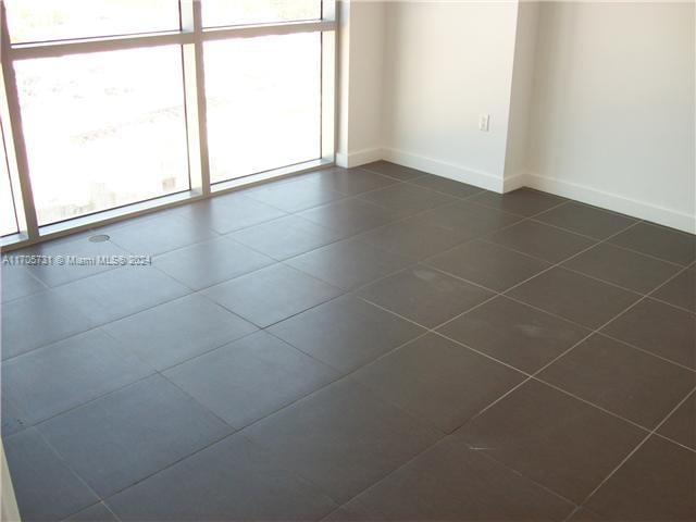 empty room with dark tile patterned flooring