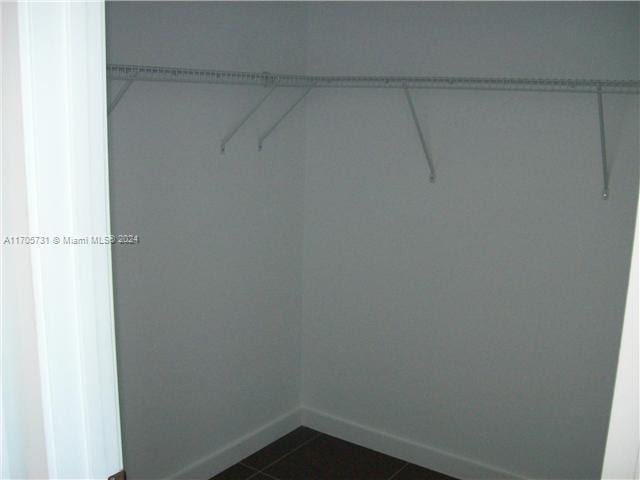 walk in closet with dark tile patterned floors