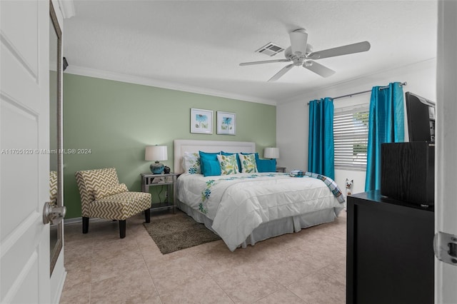 tiled bedroom with ceiling fan and ornamental molding