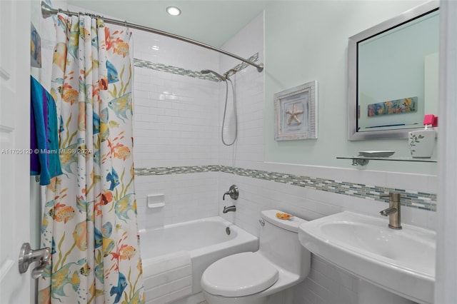 full bathroom featuring sink, shower / bath combination with curtain, tile walls, and toilet