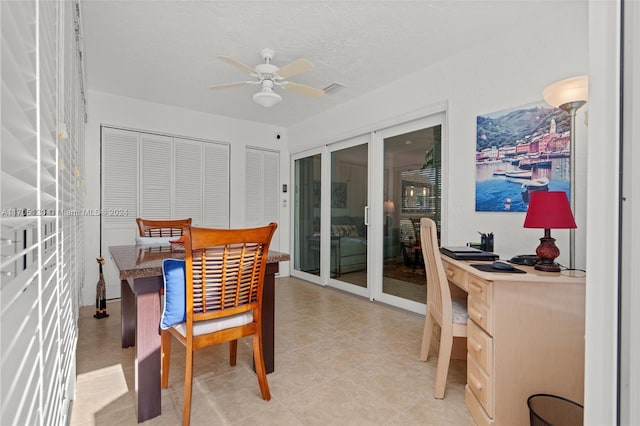 tiled dining space featuring french doors, a textured ceiling, and ceiling fan