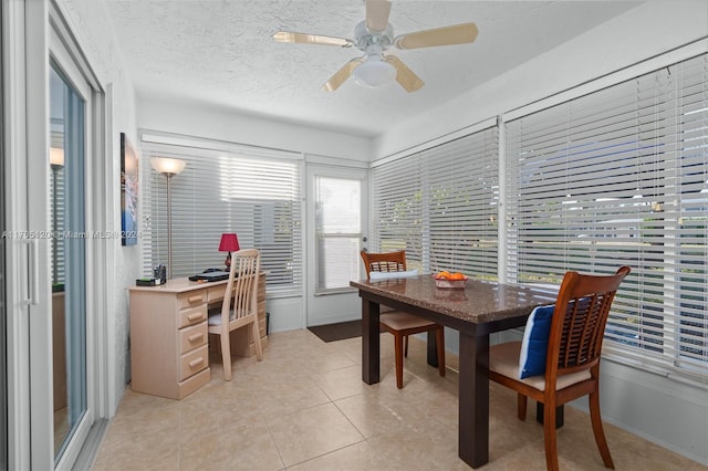 tiled dining area featuring ceiling fan and a textured ceiling