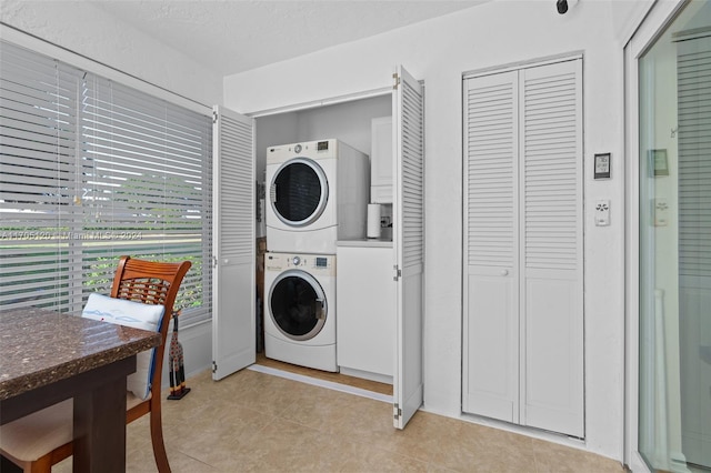 washroom featuring light tile patterned floors and stacked washer / drying machine