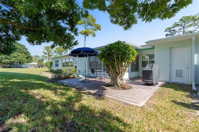 rear view of house featuring a patio area and a yard