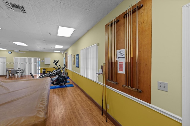 recreation room featuring hardwood / wood-style floors and a paneled ceiling