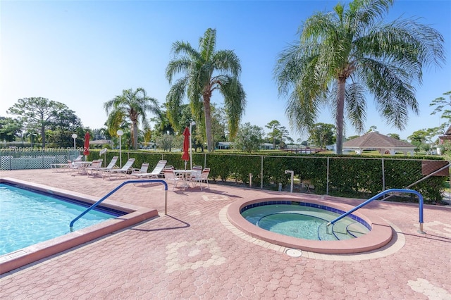 view of swimming pool featuring a patio area and a hot tub