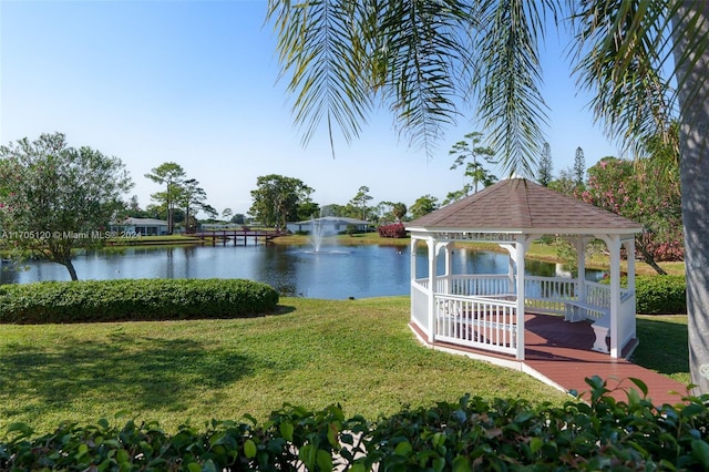 view of dock with a gazebo, a yard, and a water view