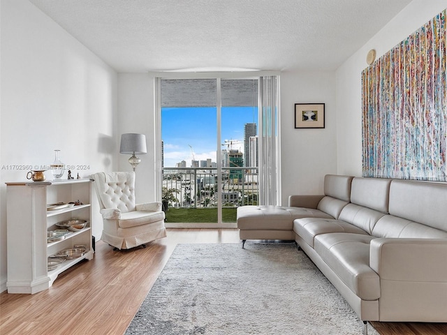 living room with hardwood / wood-style floors, floor to ceiling windows, and a textured ceiling