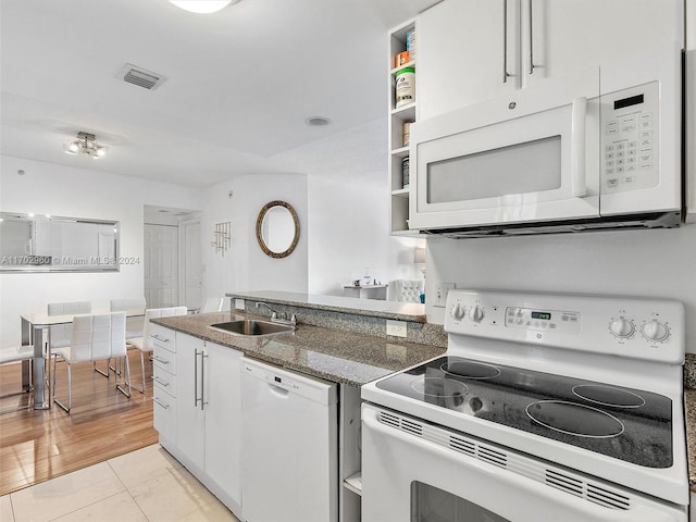 kitchen featuring sink, dark stone countertops, white appliances, white cabinets, and light wood-type flooring