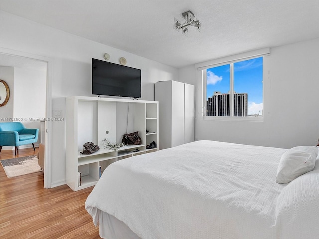 bedroom with a textured ceiling and hardwood / wood-style flooring