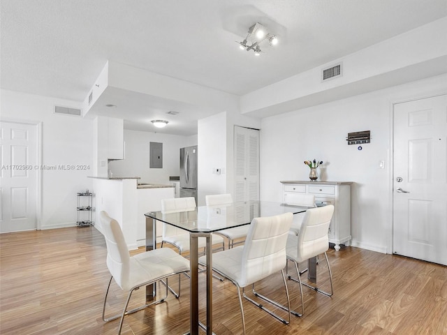 dining space featuring light wood-type flooring and electric panel