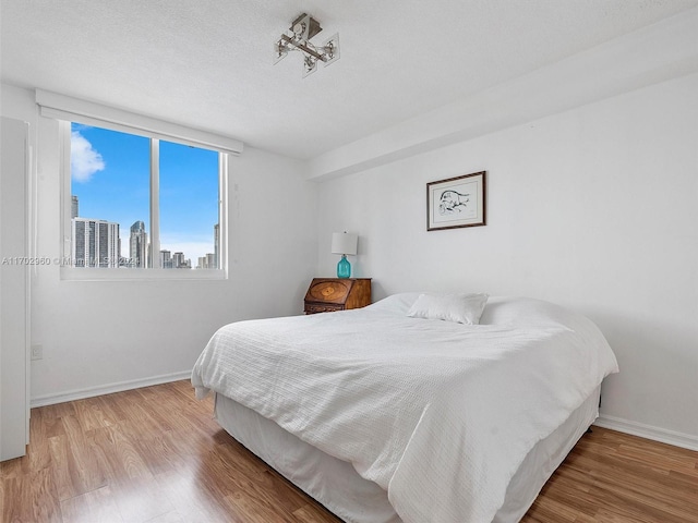 bedroom featuring hardwood / wood-style floors and a textured ceiling